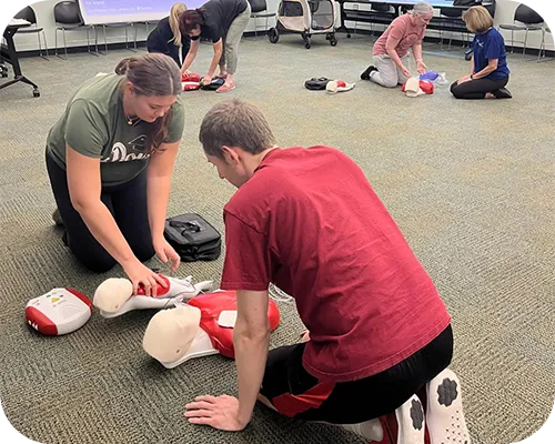 Instructor guiding participants during a hands-on CPR and AED training class